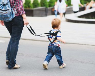 Az anya pórázt és hátizsákot rak a fiára, és elmagyarázza, miért csinálja ezt